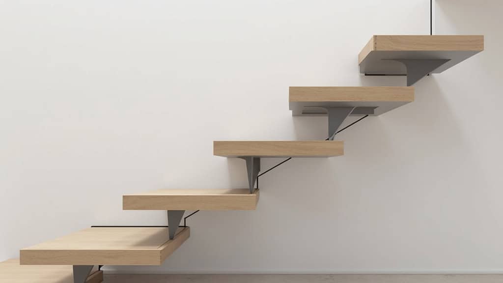 Détails d’un monte-escalier droit avec repose-pieds pliables, accoudoirs rembourrés et capteurs de sécurité, installé dans une maison bretonne