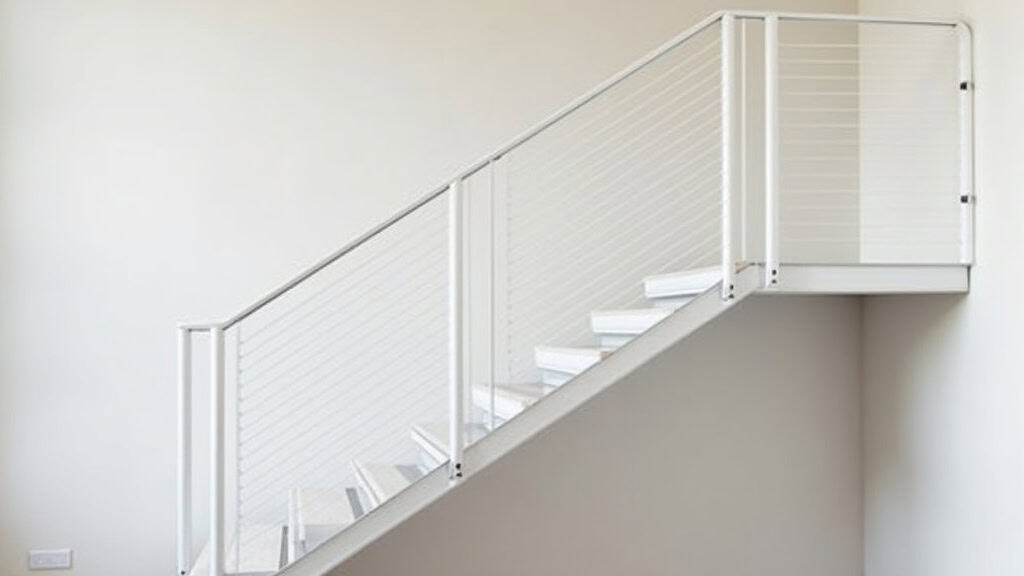 Monte-escalier droit installé dans une maison à Varennes-Changy, avec rail fixé sur les marches et siège en aluminium blanc